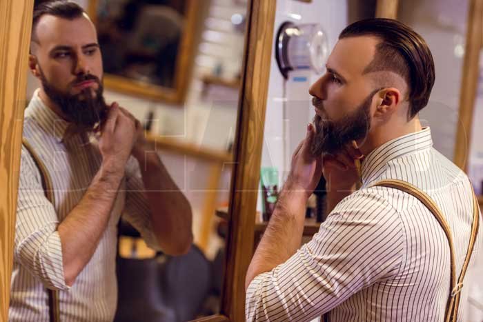 barbudo olhando no espelho com sua barba cheia