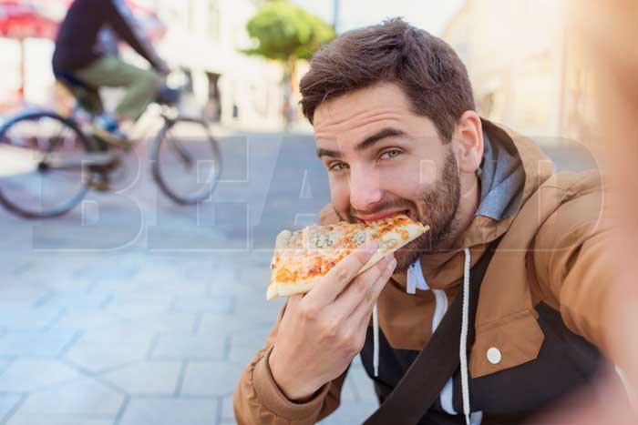 barbudo comendo pizza Não quer que a comida se prenda na barba