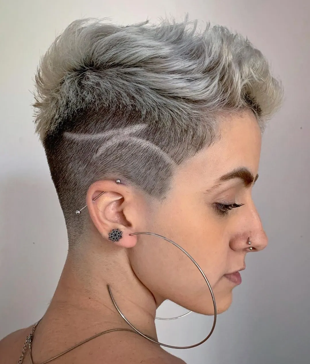 Undercut feminino curto platinado com linhas desenhadas na lateral raspada