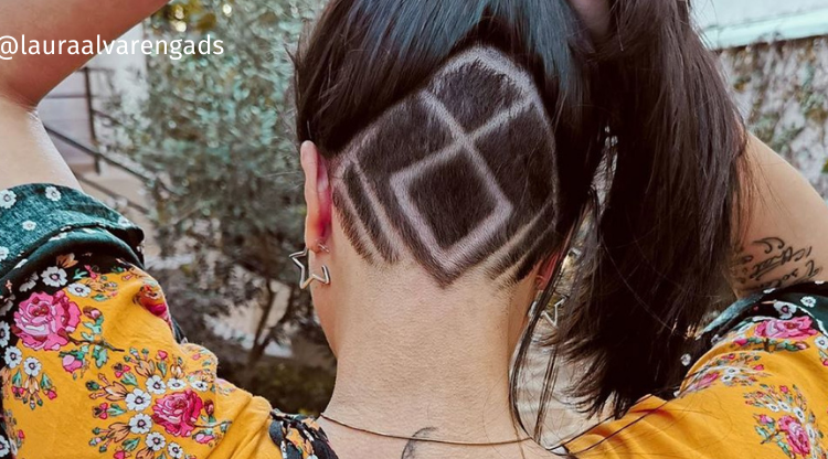 Nuca feminina raspada com desenho geométrico, cabelo longo levantado
