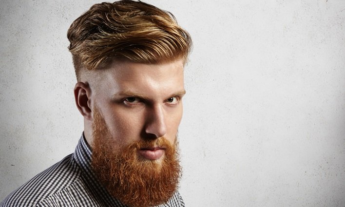 Undercut médio com lateral curta e topo de comprimento médio penteado para cima, combinado com barba longa