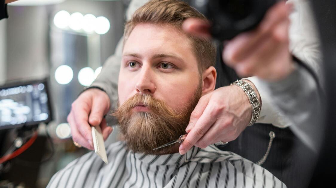 Barba sendo estilizada em barbearia