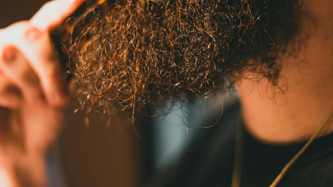 Homem alinhando a barba com escova alisadora