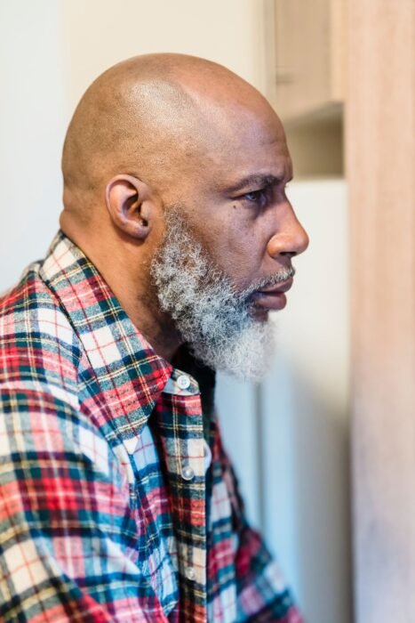 Homem de perfil com barba grisalha, com fios brancos concentrados no queixo