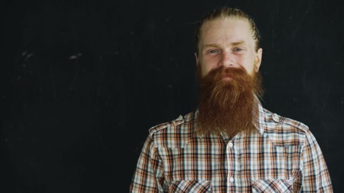 Homem de camisa xadrez com barba lenhador longa e ruiva