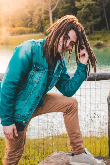 Homem de jaqueta jeans com dreads de comprimento médio e pontas mais claras