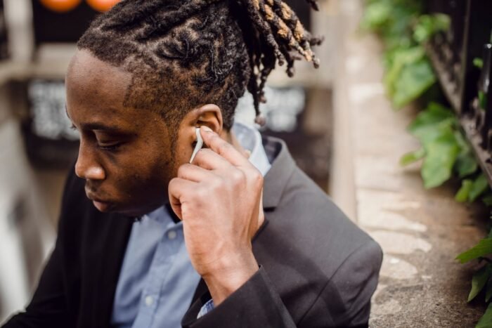 Homem de terno com dreads presos para trás em rabo de cavalo