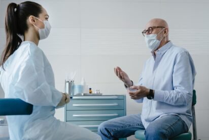 Homem de meia-idade conversando com profissional de saúde em consultório sobre exame de próstata