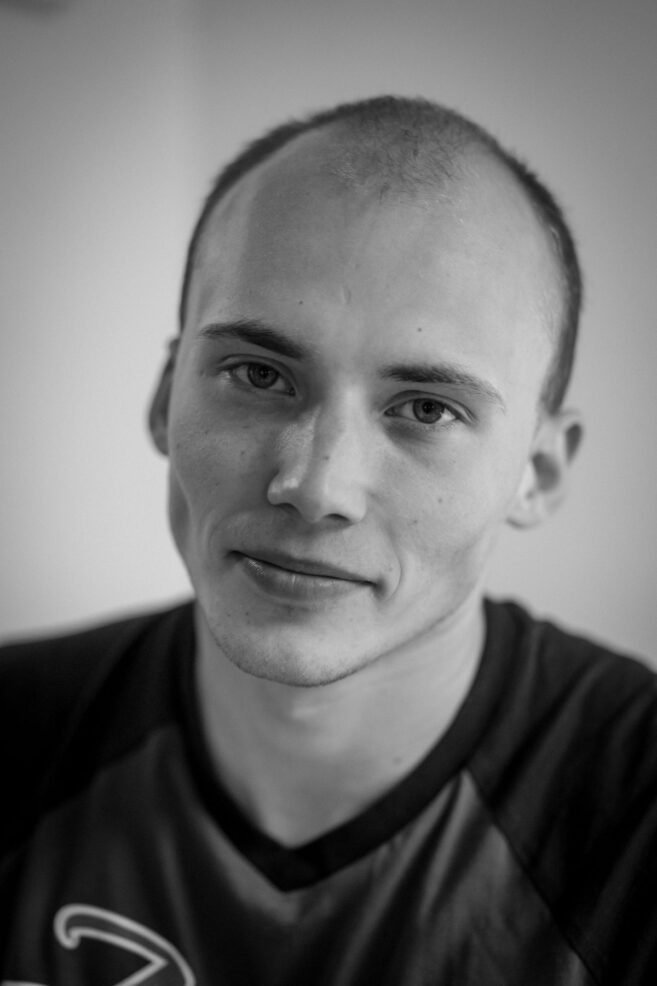 Retrato em preto e branco de homem jovem com entradas e cabelo ralo no topo