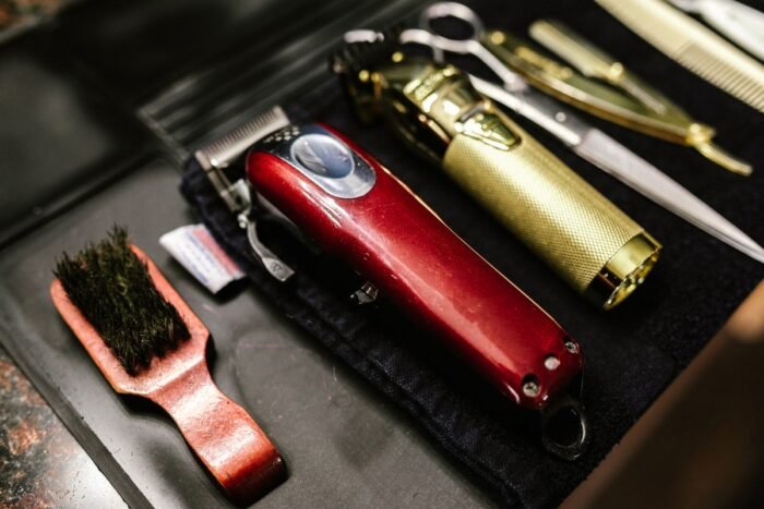 Máquinas de cortar cabelo sem fio, tesoura e escova sobre tapete de barbearia