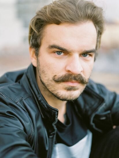Homem de bigode cheio olhando para a câmera, visual típico do Novembro Azul