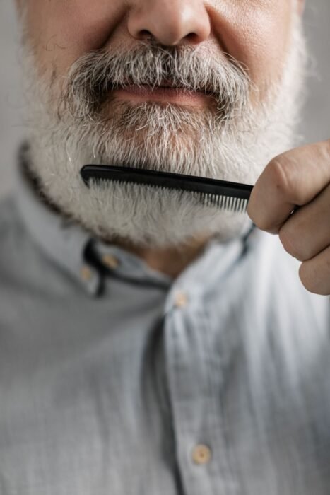 Homem penteando a barba branca com um pente fino