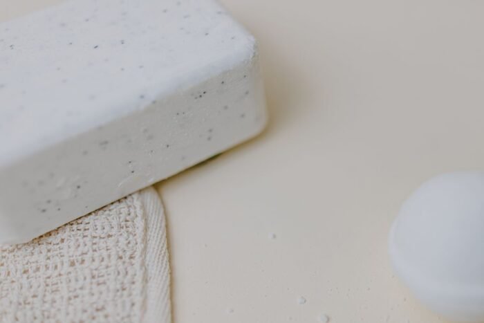Barra clara de shampoo sólido apoiada sobre bucha de tecido natural